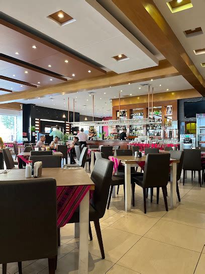 Interior del restaurante Olivo Limón con estaciones de comida peruana, incluyendo ceviches y arroces con mariscos.