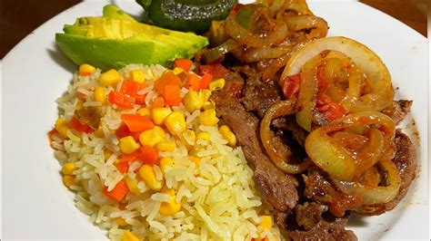 Plato de bistec encebollado con arroz y acompañamientos