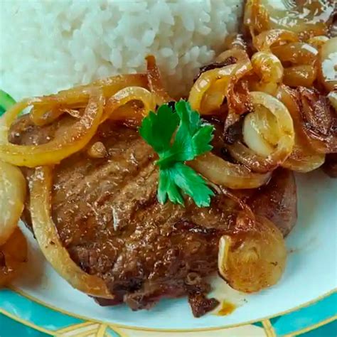 Ingredientes frescos para bistec encebollado: cebolla, ajo, carne y especias