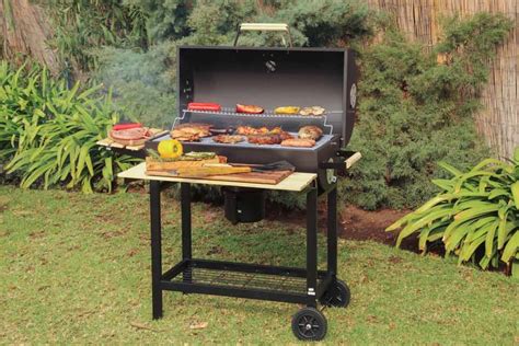 Esquema técnico de la parrilla BBQ Grill destacando la altura ajustable de la bandeja de carbón y la ubicación del termómetro.