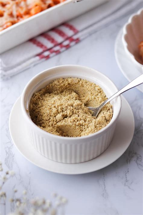 Fotografía de un queso parmesano vegano espolvoreado sobre un plato de pasta.