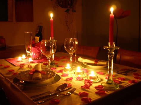 Mesa romántica decorada con platos horneados y velas para una cena de San Valentín