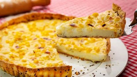 Fotografía de una tarta casera de pescado y choclo dorada al horno servida en una mesa rústica
