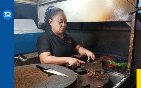 Mujer parrillera profesional trabajando en la brasa con maestría