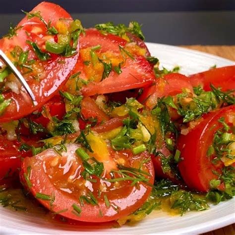 Plato de ensalada de tomate fresco con hierbas aromáticas y aceite de oliva