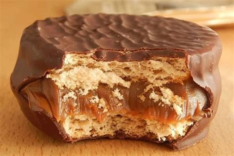Esquema de la composición de un alfajor: capas de masa, relleno de dulce de leche y cobertura de chocolate oscuro.
