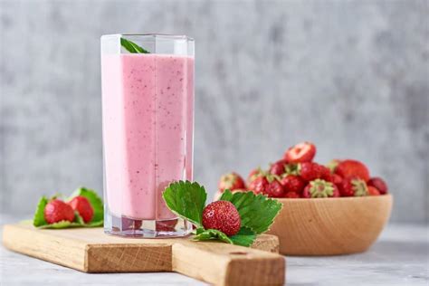 Batido refrescante de frutillas con leche condensada y menta en vaso alto
