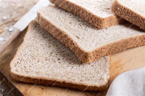 Foto de pan de semillas cortado en rebanadas sobre una tabla de madera