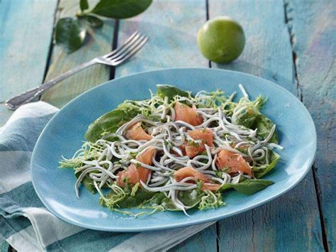 Plato de ensalada clásica de gulas y salmón ahumado con rodajas de limón