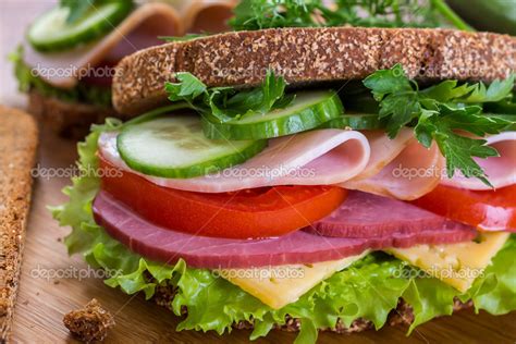Esquema comparativo entre un sándwich procesado (pan blanco y embutidos) y un sándwich saludable (pan integral, vegetales y proteínas magras)