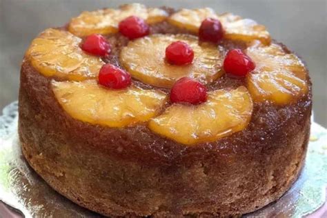 Fotografía profesional de una torta de piña esponjosa con capas de crema y trozos de fruta decorativa
