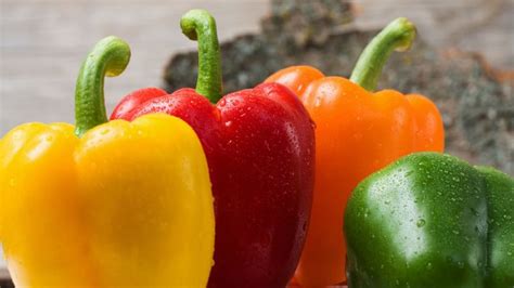 Pimientos morrones de varios colores cortados a la mitad y listos para rellenar