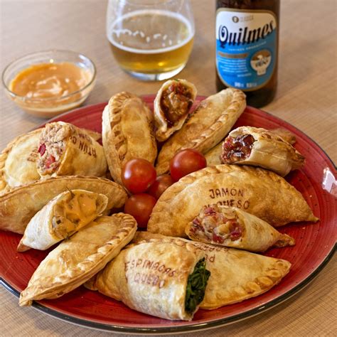Fotografía gastronómica de una selección de empanadas artesanales con texturas doradas y rellenos variados