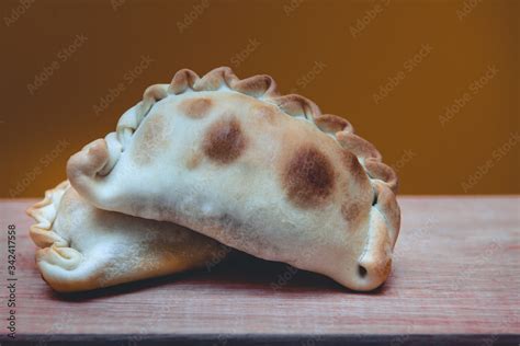 Primer plano de una empanada chilena tradicional, destacando sus ingredientes y masa.