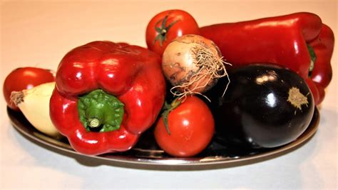 Imagen variada de verduras frescas listas para asar: pimientos, berenjenas, tomates y cebollas