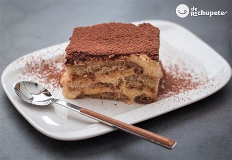 Fotografía profesional de un postre estilo tiramisú servido en fuente rectangular con espolvoreado de cacao