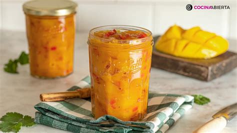 Un frasco de chutney de mango junto a unas chuletas de cerdo.