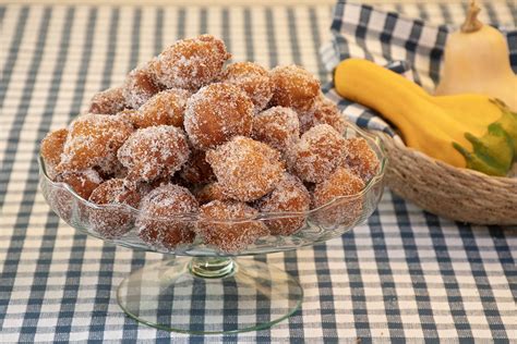 Plato con buñuelos de calabaza caseros, decorados con un toque de azúcar glas.