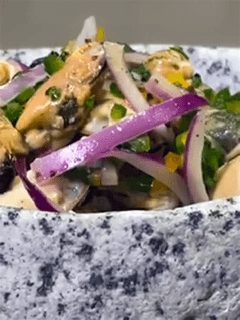 Plato de ceviche de choritos frescos servido en un bol, con cebolla morada y cilantro.