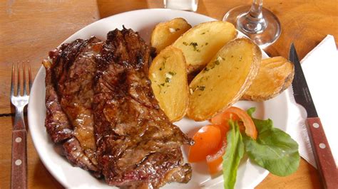 Plato de carne al horno servido con guarnición y reducción de vino