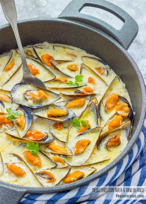 Fotografía detallada de los mejillones abriéndose en la cazuela con vino blanco.