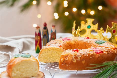 Primer plano de un roscón de Reyes con una figurita asomando