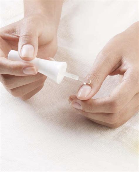 Mujer aplicándose aceite de almendras en las uñas