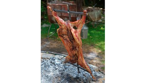 Imagen de un asado a la cruz con un cordero entero.