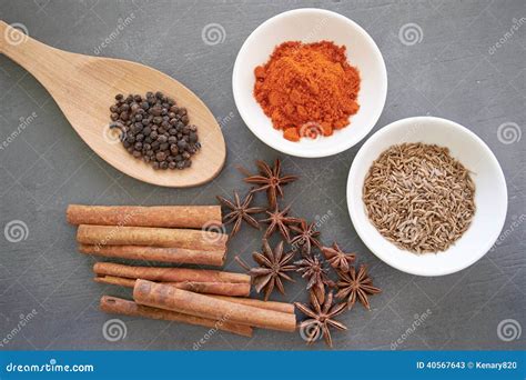 selección de especias secas enteras y molidas: canela, comino, pimienta negra, clavos de olor