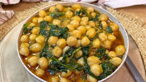 Imagen de un plato humeante de garbanzos con trozos de calabaza y espinacas verdes