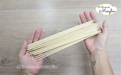 Conjunto de tres adornos esféricos para escritorio, hechos con trozos de palitos de brochetas pegados a pelotas de telgopor, montados sobre palos gruesos y bases de cajitas.