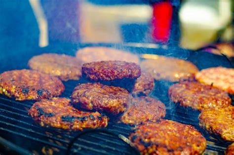 Fotografía de hamburguesas cocinándose en una plancha, con marcas de parrilla visibles