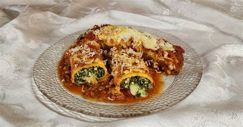 Plato principal de arrolladitos de acelga gratinados con salsa y queso