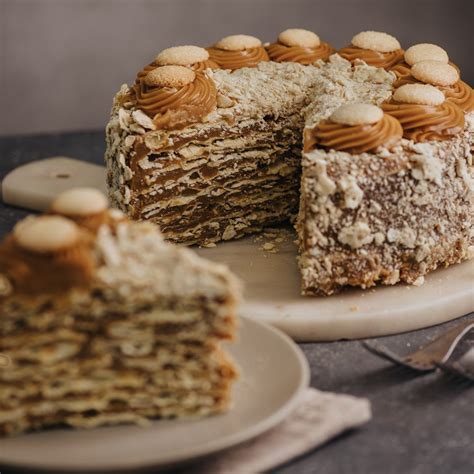 Fotografía profesional de una torta de hojarasca decorada con frambuesas frescas y una textura suave de crema.