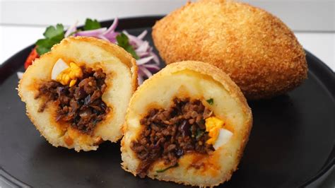 Fotografía detallada de una papa rellena cortada a la mitad mostrando el relleno de carne y huevo.