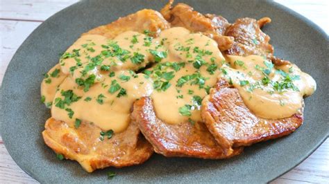 fotografía de un plato de filete de cerdo cortado en rodajas, cubierto con una salsa cremosa