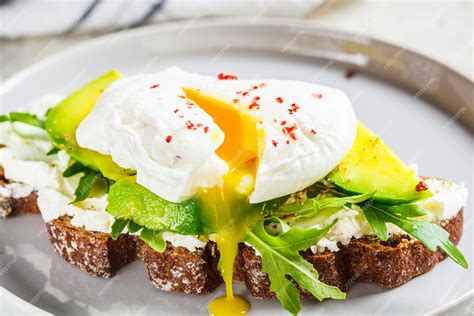 Plato de tostadas con huevo escalfado, aguacate y tocino