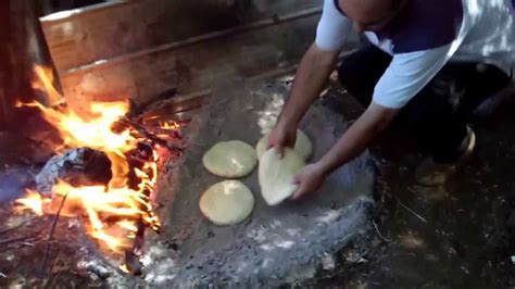 Fotografía detallada de una tortilla de rescoldo recién salida del horno de arena con su característica costra dorada