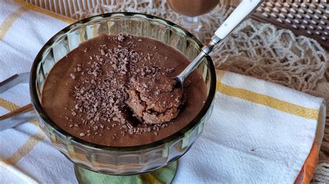 Fotografía detallada de una crema de chocolate vegana con textura sedosa servida en un bol elegante.