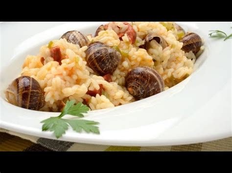 Plato de arroz con caracoles servido en una cazuela tradicional