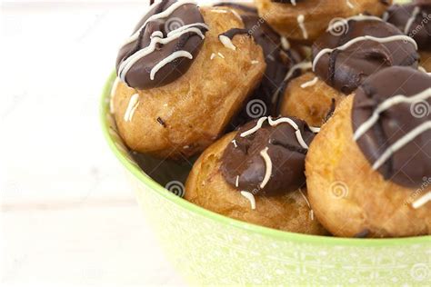 Foto temática de repollitos/profiteroles terminados, apilados y cubiertos de chocolate