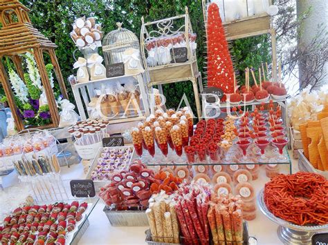 Mesa decorada con una selección de snacks dulces y salados acompañados de diversas bebidas para una fiesta