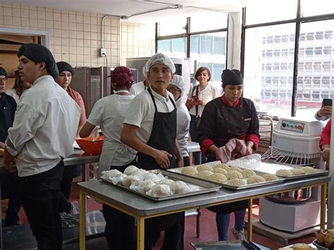 Jóvenes con discapacidad trabajando en un taller de panadería, horneando y decorando productos.