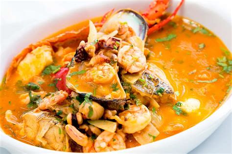 Una colorida parihuela de mariscos y bonito, adornada con yuyo y rocoto.