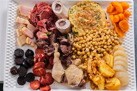 Una imagen detallada de los ingredientes para el cocido madrileño, incluyendo carnes, huesos, garbanzos y verduras.