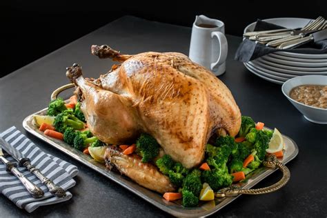 Pavo horneado dorado acompañado de guarnición de arroz y salsa gravy en una mesa festiva