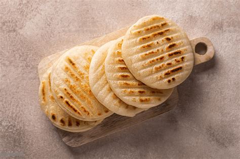 Esquema visual mostrando cómo añadir avena, semillas o vegetales a la masa de arepa