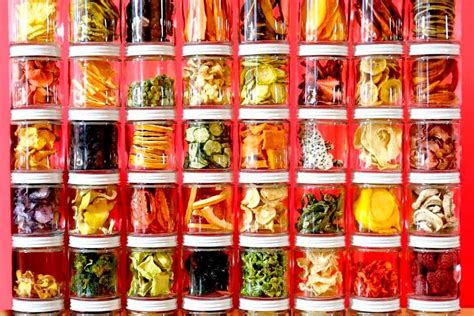 Ilustración de tarros de cristal herméticos llenos de frutas y verduras deshidratadas.
