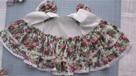 Ejemplo de un vestido de princesa para muñeca de trapo con detalles de encaje y lazos.