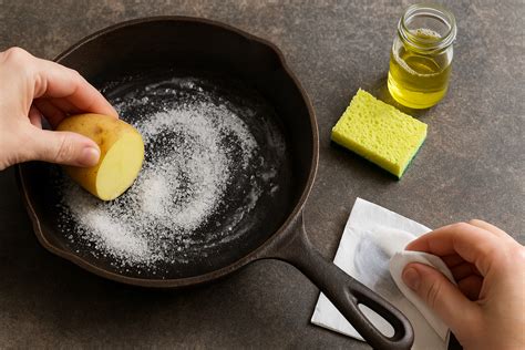 Persona aplicando aceite a una sartén de hierro fundido con papel de cocina